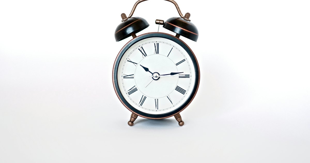 Ilustración de un reloj sobre fondo terracota con estrellas de cuatro puntas